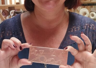 Participante heureuse de présenter sa plaque en cuivre gravée lors d'un atelier de gravure sur métal animé par Muriel Carcagno au Pays Basque.