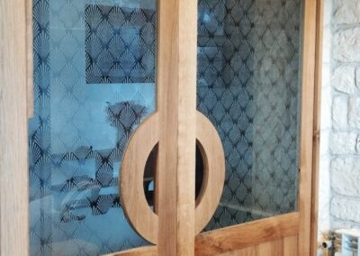 Porte coulissante en bois avec gravures sur cuivre et aluminium réalisées sur mesure pour un projet d'aménagement intérieur. Pays basque
