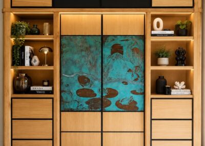Meuble contemporain en bois avec portes en cuivre gravé à la main et patine vert-de-gris, création artisanale sur mesure.