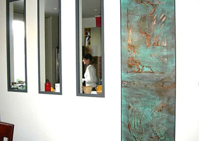 Habillage de portes de placard sur mesure en cuivre gravé et patiné réalisé par Muriel Carcagno, artiste graveuse sur métal à Bayonne.